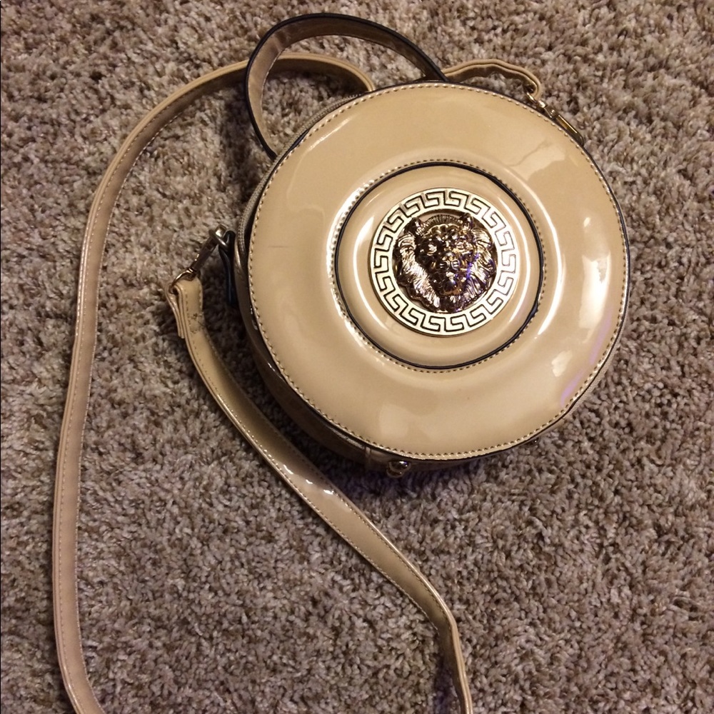 Really cool tan purse with a gold lion face.